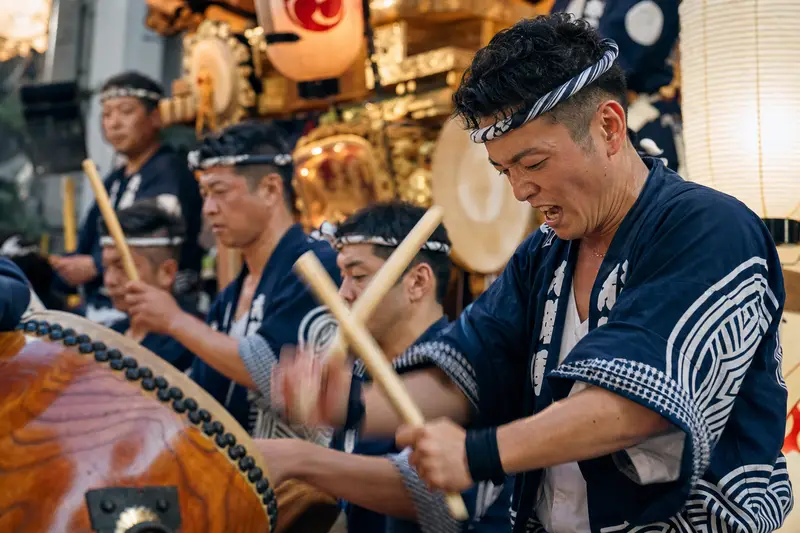 小倉祇園太鼓祭表演者在山車上擊打太鼓的特寫。