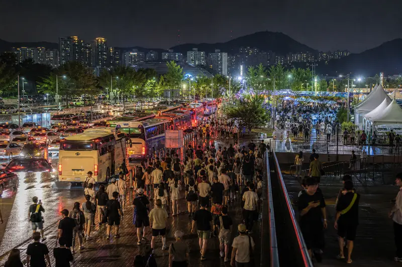 韓國夏季音樂祭散場後的人潮、巴士與夜間交通情境。