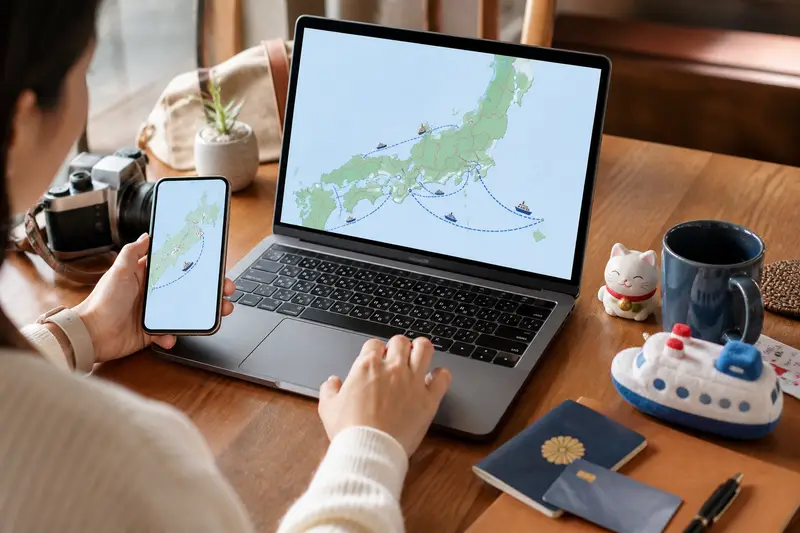 旅人使用筆電查詢日本渡輪預約資訊，旁邊放著護照與旅行小物。