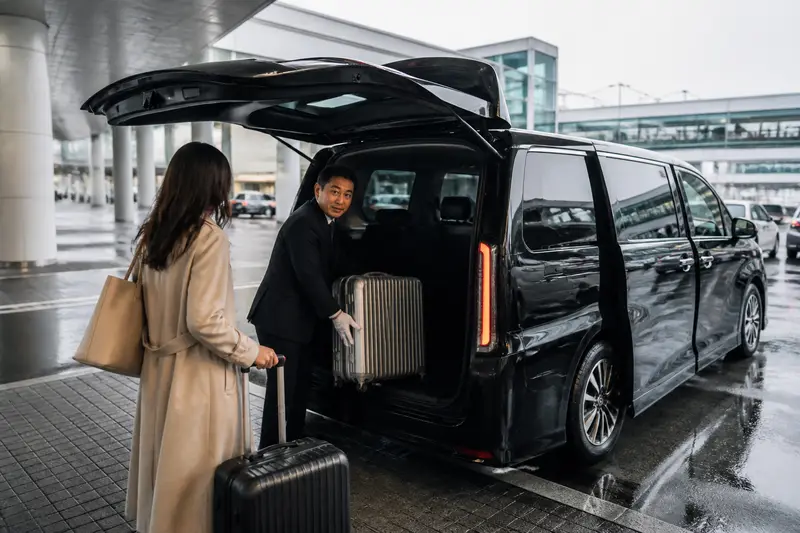 新千歲機場外的專車，中文司機協助搬行李上車，準備開往小樽