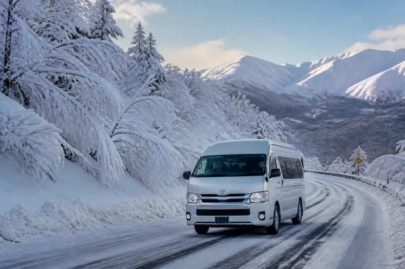 冬季八甲田山區雪路上的包車廂型車，載旅客前往樹冰與溫泉
