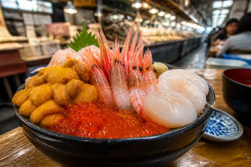 函館朝市攤位上的豪華海鮮丼，鋪滿海膽、鮭魚卵、甜蝦與干貝