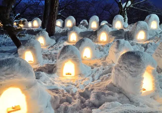 弘前公園蓮池周邊成排的燭光迷你雪屋，雪地上點點暖光