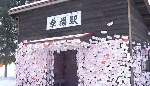 幸福車站，粉紅色車票貼滿站舍與舊車廂，遊客拍照