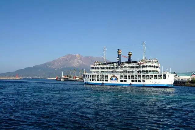 櫻島渡輪甲板上回望鹿兒島市區與海面，短程渡輪航行畫面