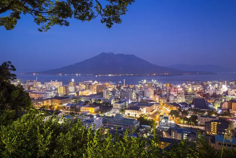 從城山展望台俯瞰鹿兒島市區、錦江灣與對岸的櫻島，傍晚時分