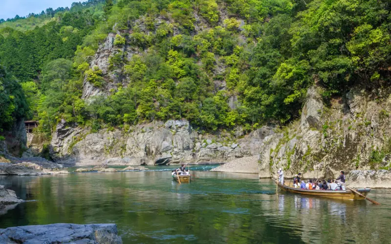 保津川遊船木船在溪谷激流中順流而下
