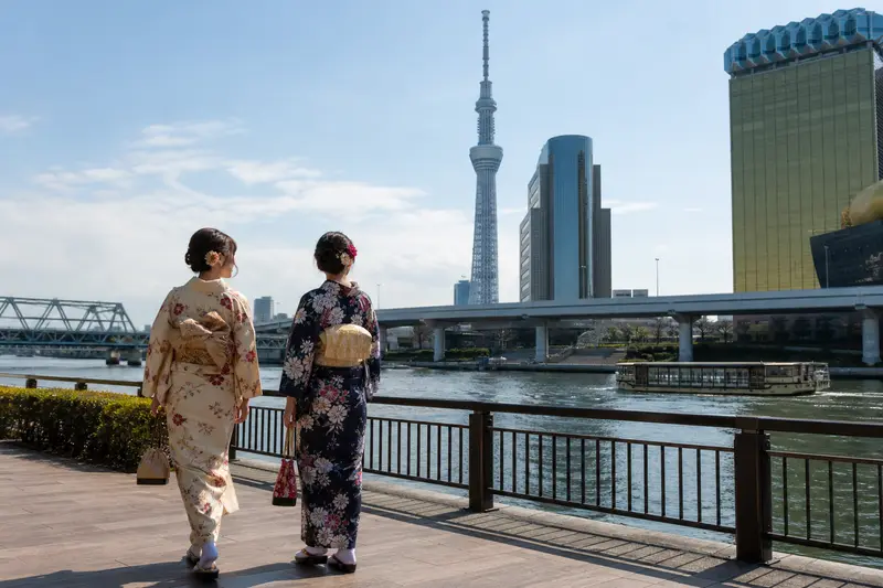 旅人穿和服走在淺草隅田川旁，背景可見東京晴空塔。