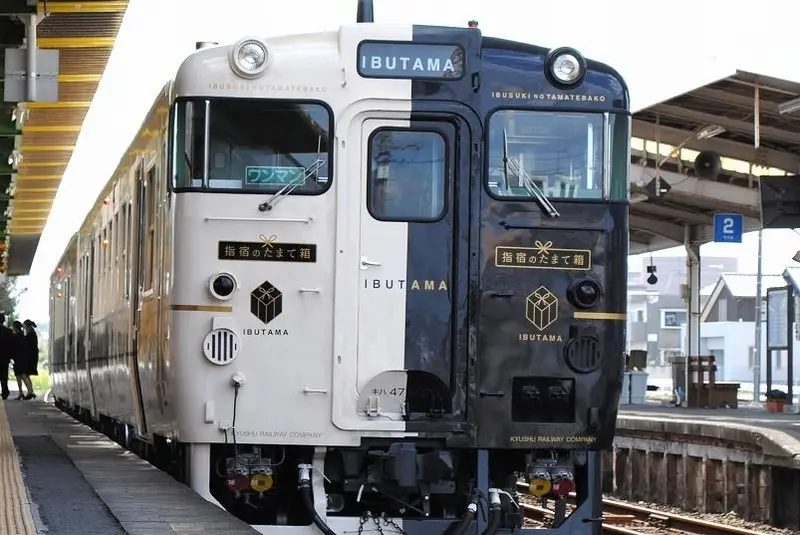 指宿玉手箱列車黑白各半的獨特車身，停靠海邊車站