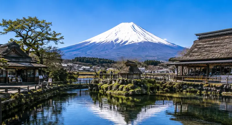 忍野八海清澈湧泉池與背後的富士山