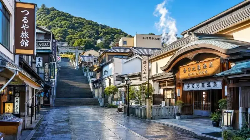 鳴子溫泉街的木造溫泉旅館與石板路，遊客散步其間