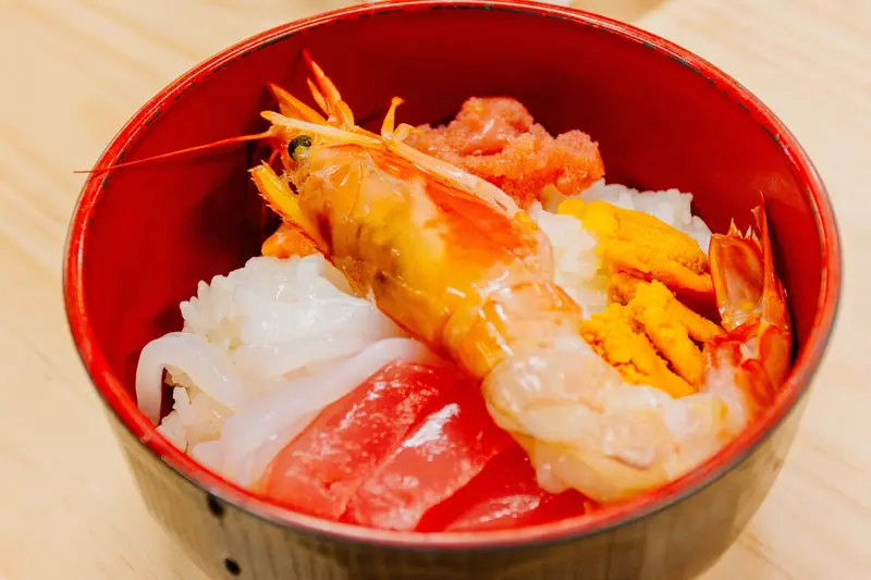 仲卸市場自製海鮮丼，白飯上鋪滿自選的生魚片與海膽鮭魚卵