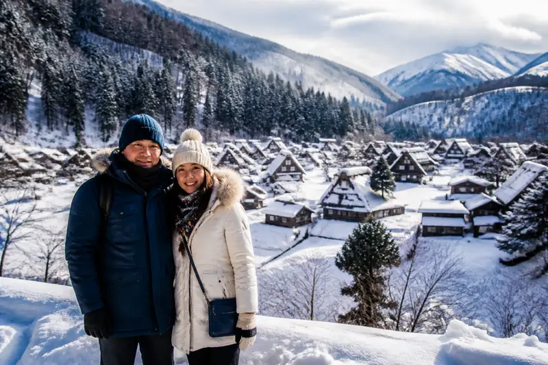 旅客穿著厚重保暖衣物在雪地中拍照留念
