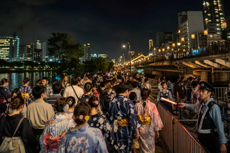 天神祭煙火結束後大阪河岸周邊人潮散場情境。