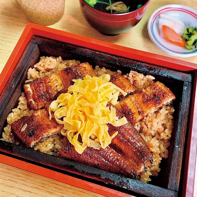 柳川名物鰻魚蒸籠飯，蒸籠上鋪滿蒲燒鰻與錦絲蛋
